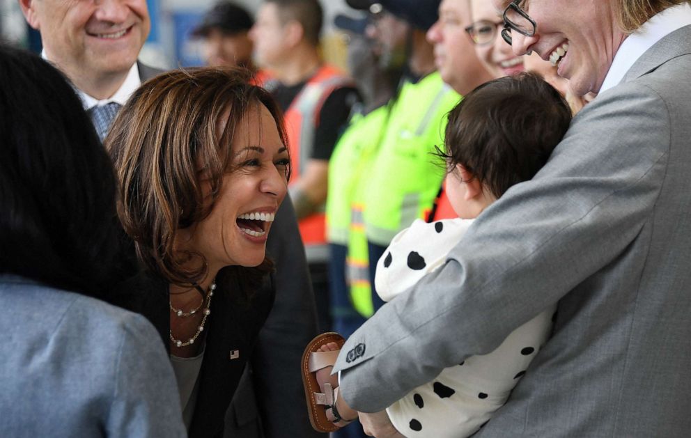 PHOTO: Vice President Kamala Harris smiles to a baby as she and Second Gentleman Doug Hemhoff, meet with aviation and transport workers who are facilitating the delivery of baby formula, at Dulles International Airport in Dulles, Va., on June 17, 2022.
