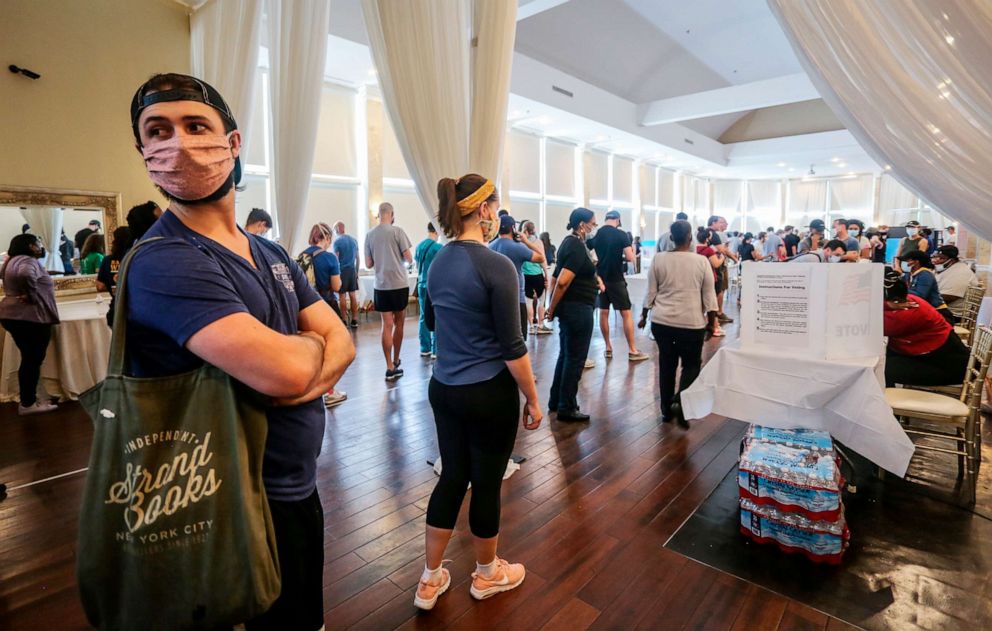PHOTO: Voters wait in line to cast their ballots in the state's primary election at a polling place in Atlanta, June 9, 2020.