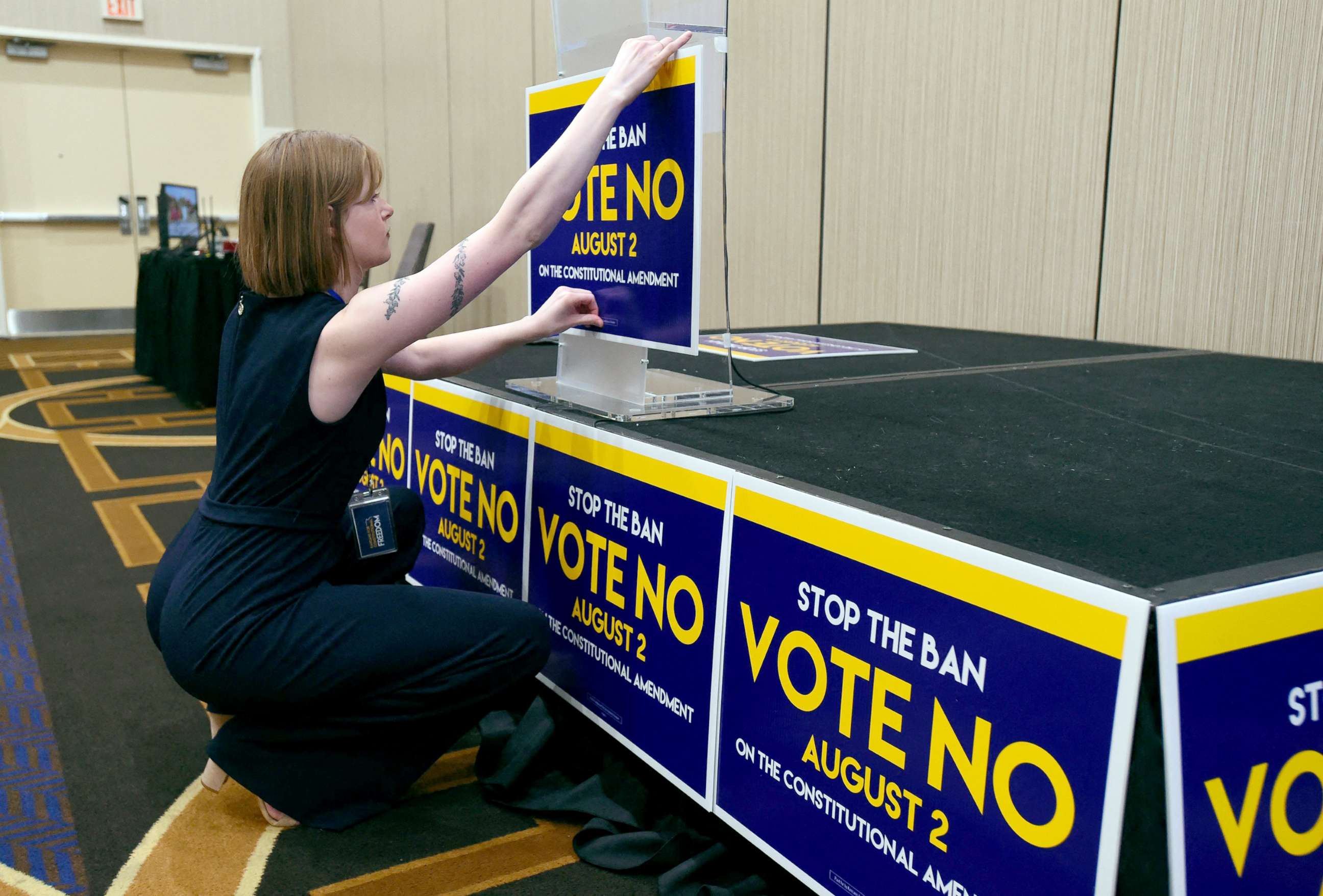 PHOTO: Field organizer Jae Grey places signs on the podium before the abortion rights advocate Kansas for Constitutional Freedom primary election watch party in Overland Park, Kansas, Aug. 2, 2022. 