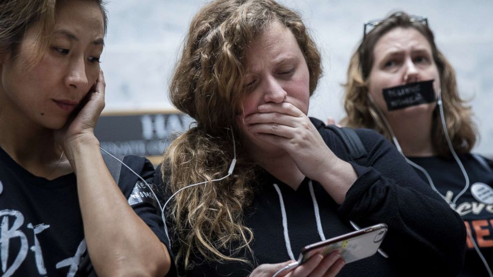 PHOTO: People rallying against Supreme Court nominee Judge Brett Kavanaugh watch testimony from Christine Blasey Ford on a smartphone inside the Hart Senate Office Building on Capitol Hill, Sept. 27, 2018 in Washington.