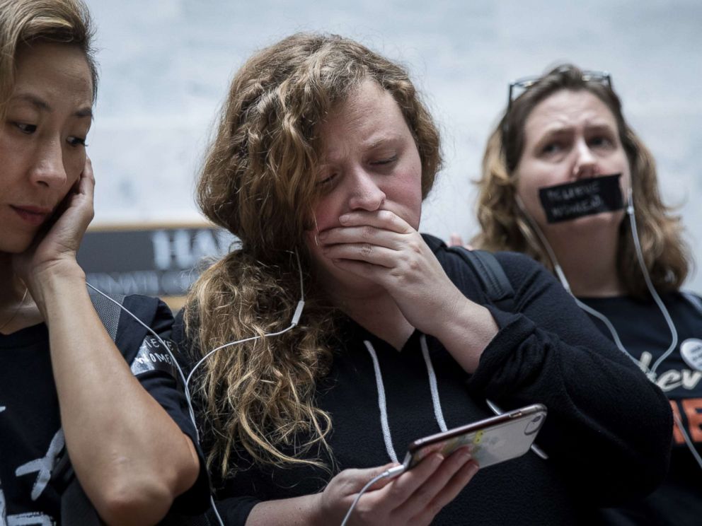 PHOTO: People rallying against Supreme Court nominee Judge Brett Kavanaugh watch testimony from Christine Blasey Ford on a smartphone inside the Hart Senate Office Building on Capitol Hill, Sept. 27, 2018 in Washington.
