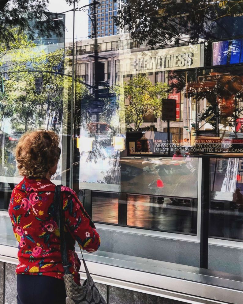 PHOTO: A woman watches testimony in the Senate Judiciary Committee hearing on a television while standing outside the ABC Television studio in New York, Sept. 27, 2018.