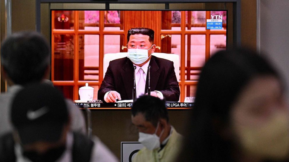 PHOTO: People sit near a screen showing a news broadcast at a train station in Seoul on May 12, 2022