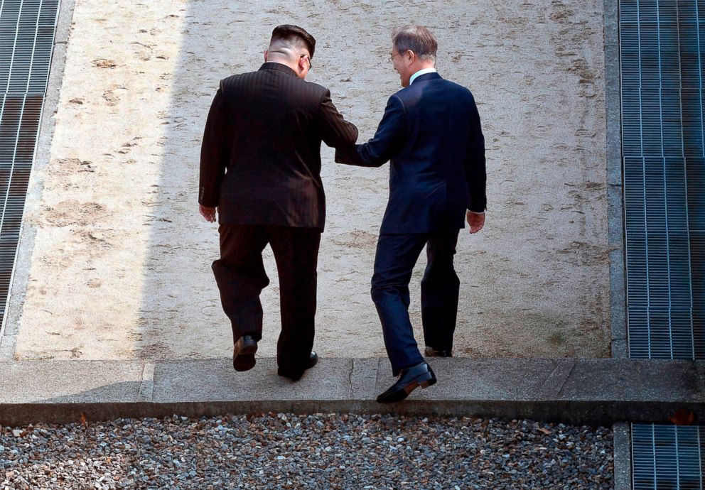 PHOTO: North Korean leader Kim Jong Un, left, and South Korean President Moon Jae-in cross the military demarcation line at the border village of Panmunjom in the Demilitarized Zone that divides the North and South, April 27, 2018. 