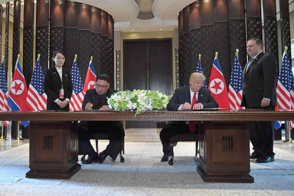 PHOTO: North Korea's leader Kim Jong Un and President Donald Trump sign documents at a signing ceremony during their historic summit in Singapore, June 12, 2018.