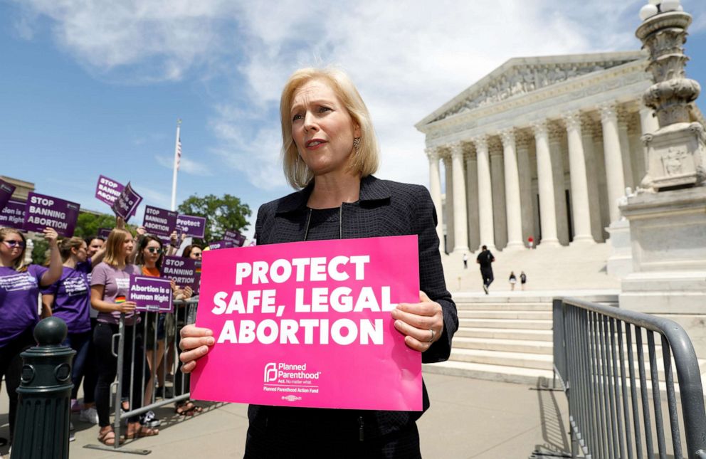 PHOTO: Presidential candidate and U.S. Senator Kirsten Gillibrand holds a protest sign in front of a crowd of abortion rights demonstrators during a rally outside the U.S. Supreme Court in Washington, D.C., May 21, 2019.