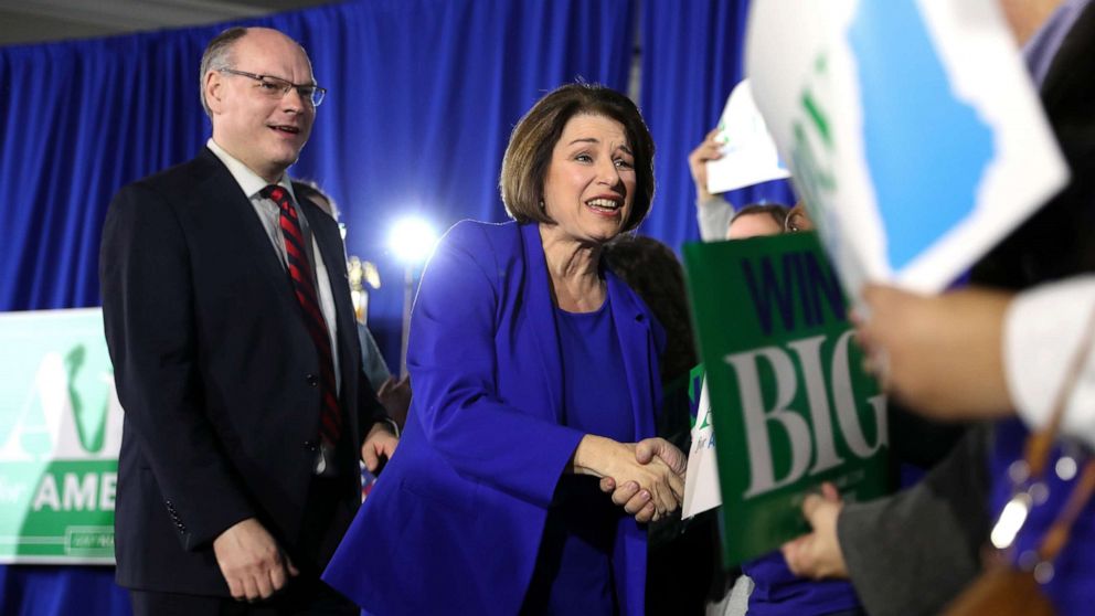 PHOTO: Democratic presidential candidate Sen. Amy Klobuchar takes the stage with spouse John Bessler during a primary night event, Feb. 11, 2020, in Concord, N.H.