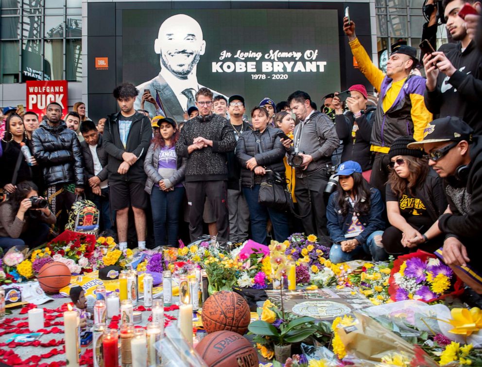 PHOTO: People gather in front of a makeshift memorial for former NBA and Los Angeles Lakers player Kobe Bryant and his daughter Gianna Bryant, on Jan. 26, 2020, at LA Live plaza in front of Staples Center in Los Angeles.