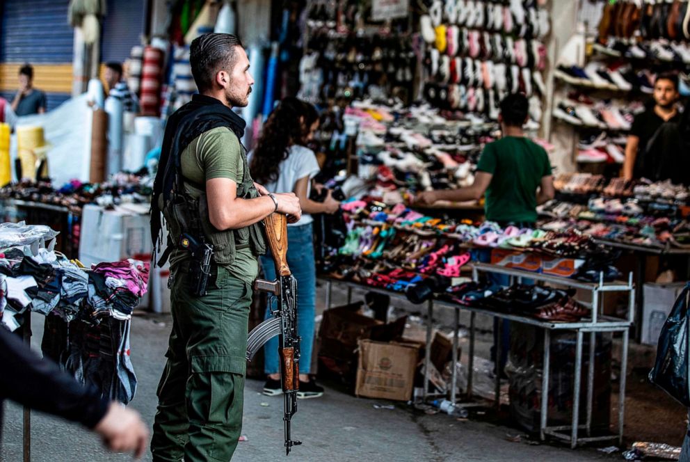 PHOTO: A member of the Kurdish Internal Security Police Force of Asayish stands guard at a market in the northeastern Syrian city of Qamishli on August 5, 2019.