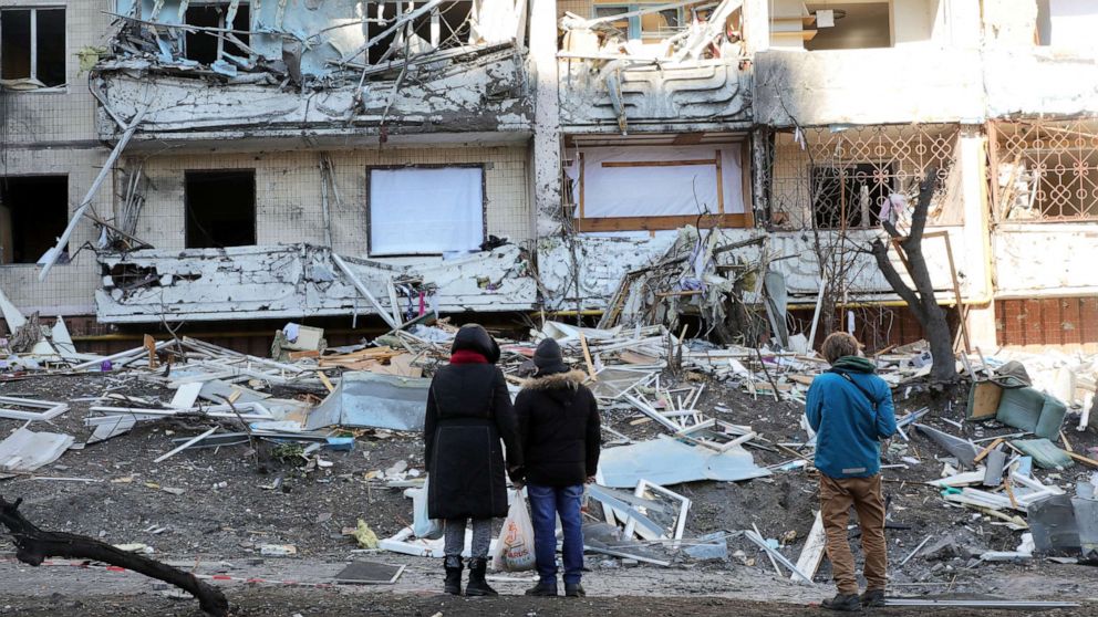 PHOTO: People look at damage caused by a shelling that took place early in the morning to a ten-story apartment block in the Podilskyi district of Kyiv, Ukraine, on March 15, 2022.