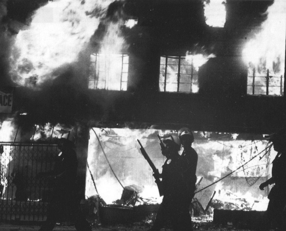 PHOTO: Police officers stand watch over burning building in West Los Angeles following looting and arson reaction to the acquittal of four LAPD officers in the Rodney King incident, April 30, 1992 in Los Angeles.