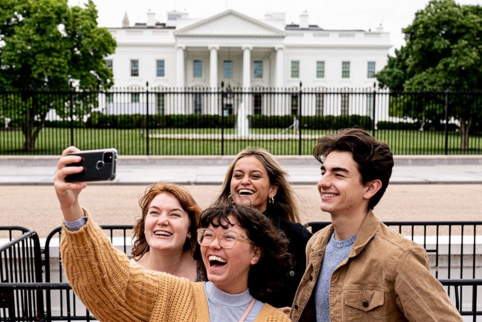 PHOTO: From left, Eliana Lord, Carly Mihovich, Stephanie Justice, and Nick Hansen, visiting from Columbia, S.C., take a photo at Lafayette Park, across the street from the White House, after it reopens in a limited capacity in Washington, May 10, 2021.