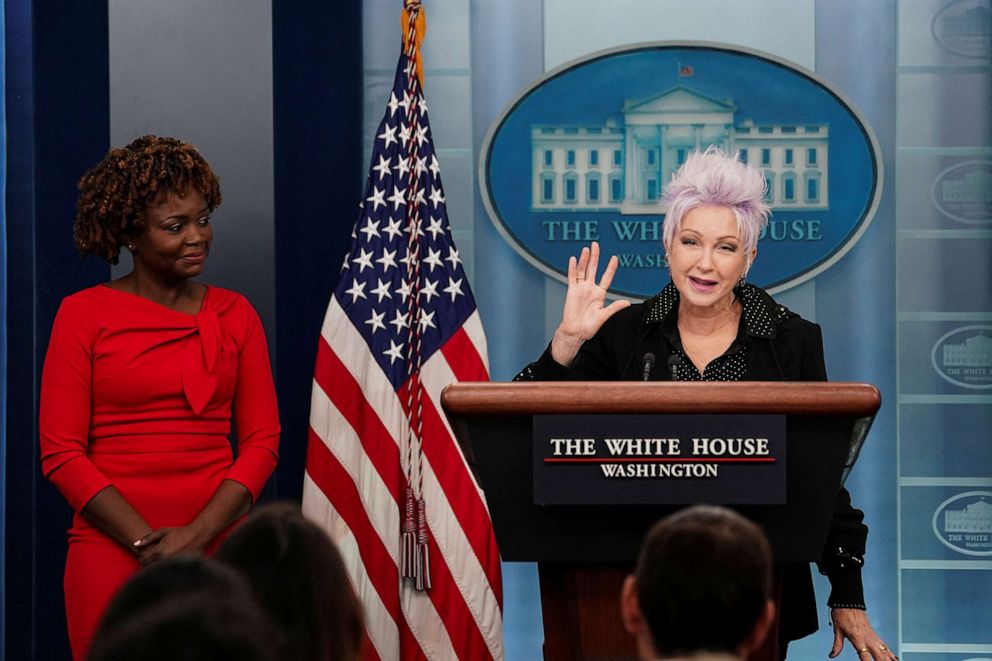 White House Press Secretary Karine Jean-Pierre observes as Cyndi Lauper, who will be performing at the signing ceremony for the "Respect for Marriage Act," addresses reporters during the daily press briefing at the White House in Washington, Dec. 13,2022.