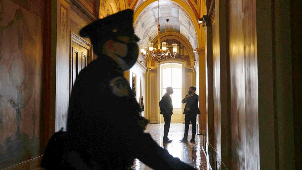 PHOTO: A police office walks through the hallways of the Senate in Washington, Jan. 6, 2022.