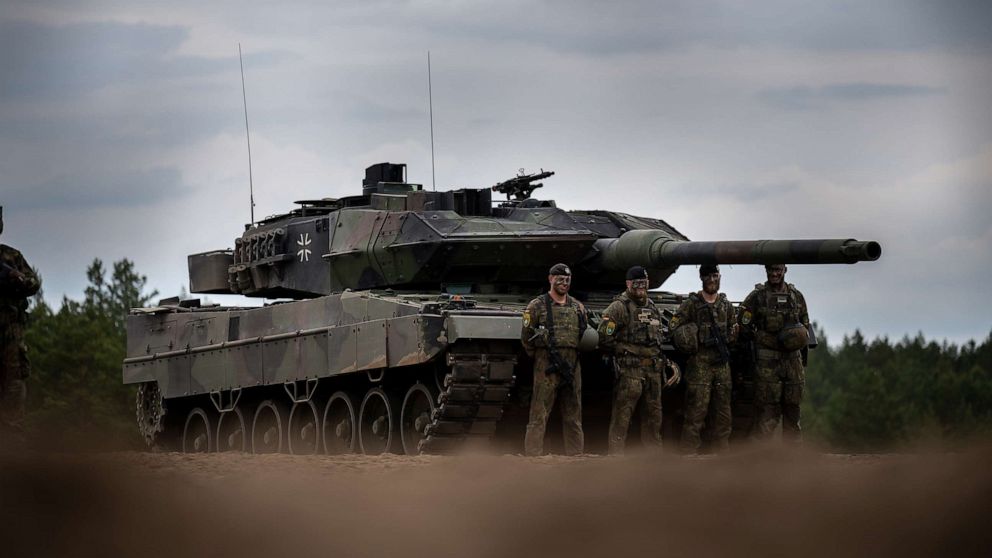 PHOTO: Soldiers stand in front of a German Army Leopard-2 tank used by the NATO Enhanced Forward Presence Battle Group during Chancellor Scholz's visit to Camp Adrian Rohn, June 7, 2022, in Pabrade, Lithuania.
