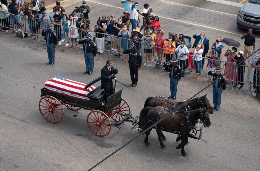 PHOTO: A horse-drawn carriage carries the body of Rep. John Lewis through downtown Selma, Ala., before crossing the Edmund Pettus Bridge, July 26, 2020.