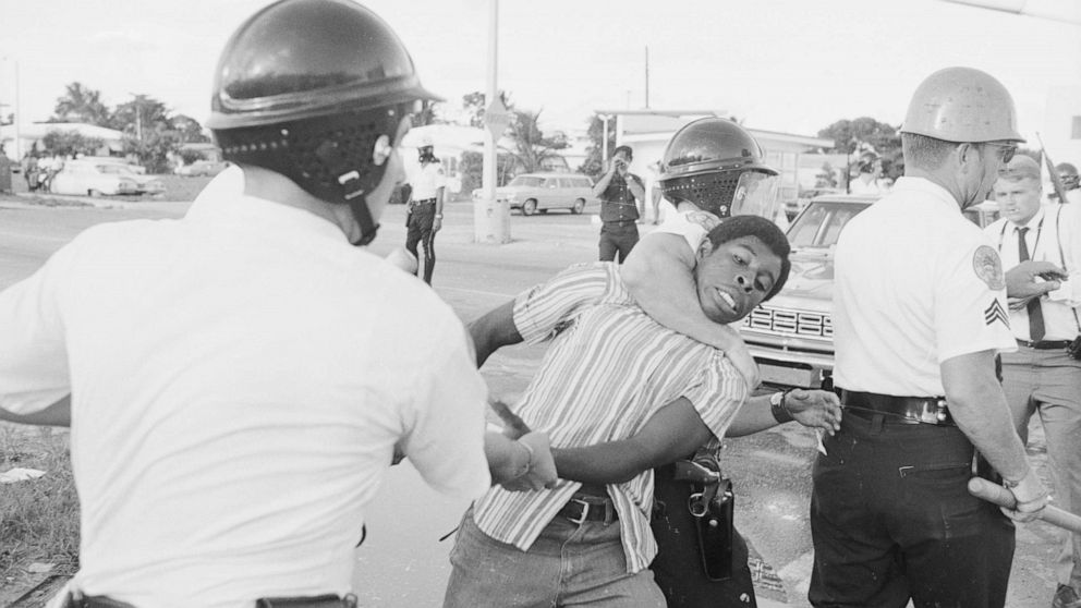 PHOTO: Miami policemen, one holding the man's arm and the other with an arm lock on his neck, drag away a man during a protest in Liberty City district in Miami, Aug. 8, 1968.
