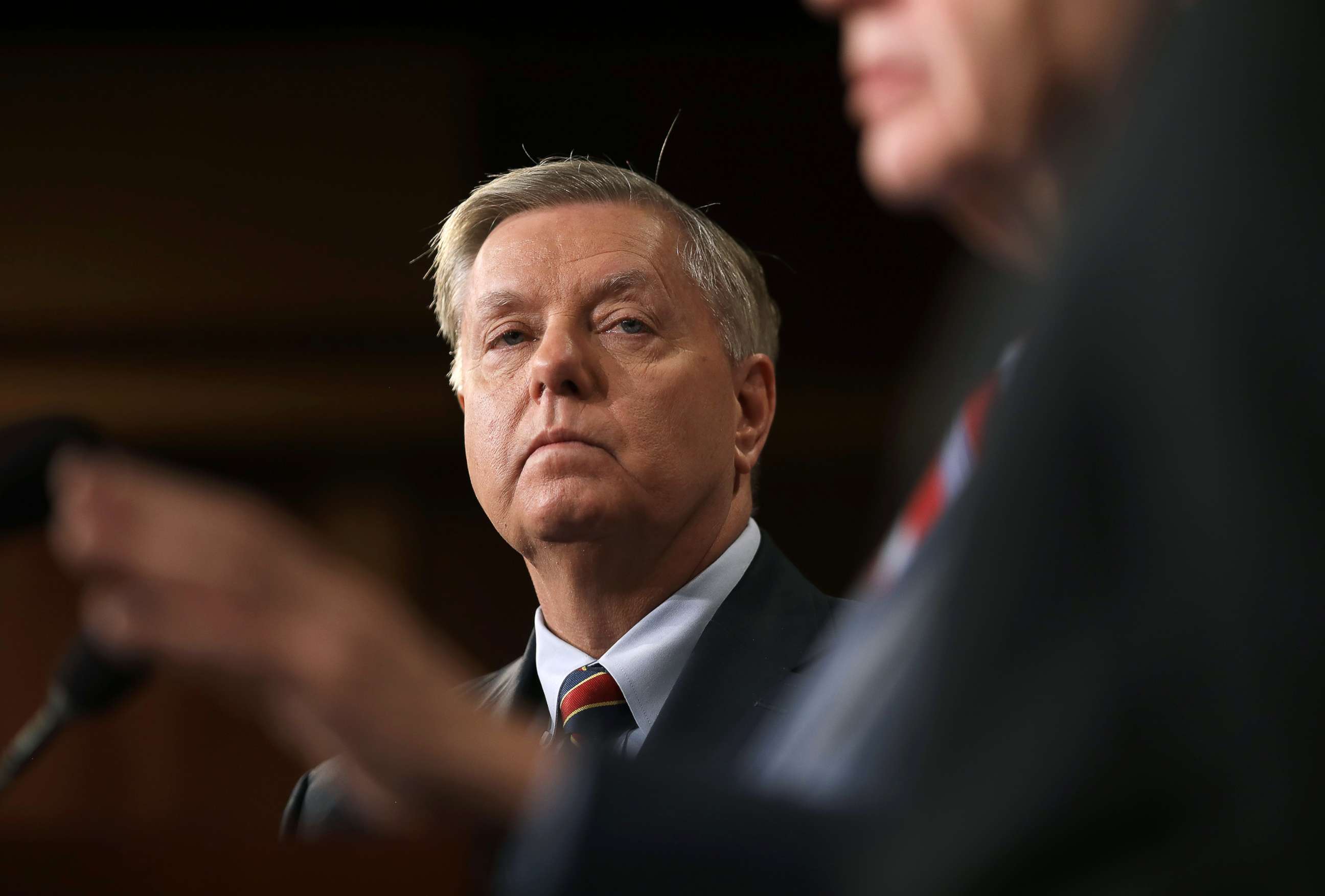 PHOTO: Sen. Lindsey Graham listens as Sen. Robert Menendez speaks during a press conference at the U.S. Capitol, Dec. 20, 2018. Graham, Menendez and Sen. Jack Reed spoke out against President Trump's decision to remove U.S. military forces from Syria.