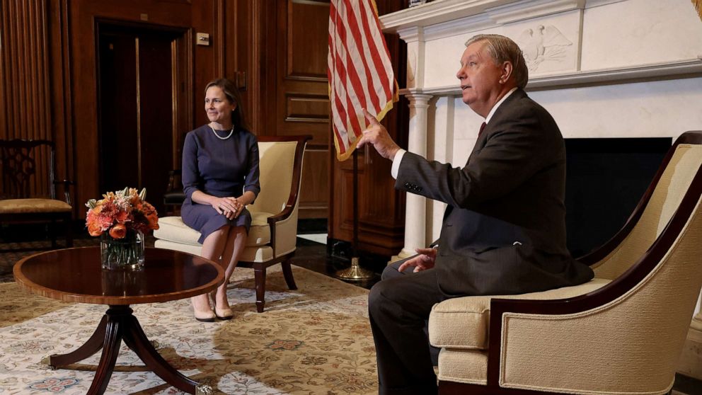 PHOTO: Seventh Circuit Court Judge Amy Coney Barrett, President Donald Trump's nominee for the Supreme Court, listens Lindsey Graham (R-SC) answers reporters' questions before a meeting in the Mansfield Room at the Capitol Sept. 29, 2020.