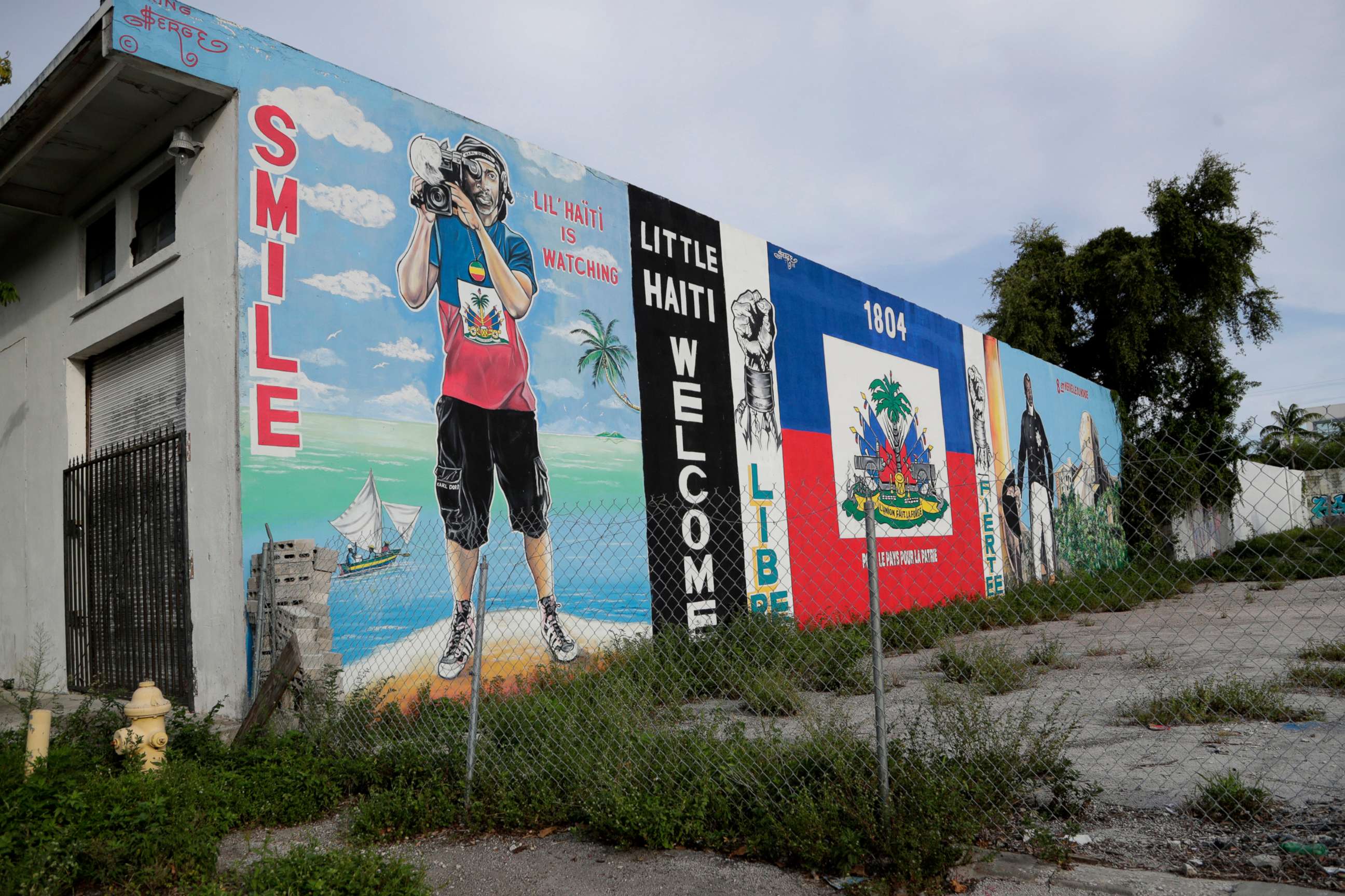 PHOTO: Murals adorn a wall next to a vacant lot in the Little Haiti neighborhood of Miami, July 16, 2019.