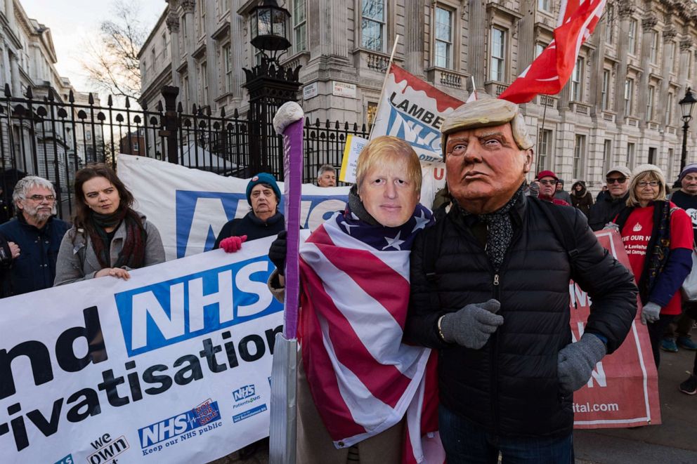 PHOTO: In this Dec. 9, 2019, file photo, demonstrators wearing masks of Donald Trump and Boris Johnson take part in a protest for keeping the National Health Service publicly owned outside Downing Street in central London.