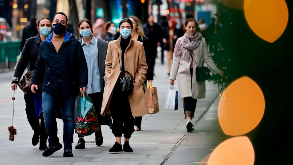 PHOTO: Pedestrians wearing a face mask or covering due to the COVID-19 pandemic, walk along Oxford Street in central London, Dec. 22, 2020.
