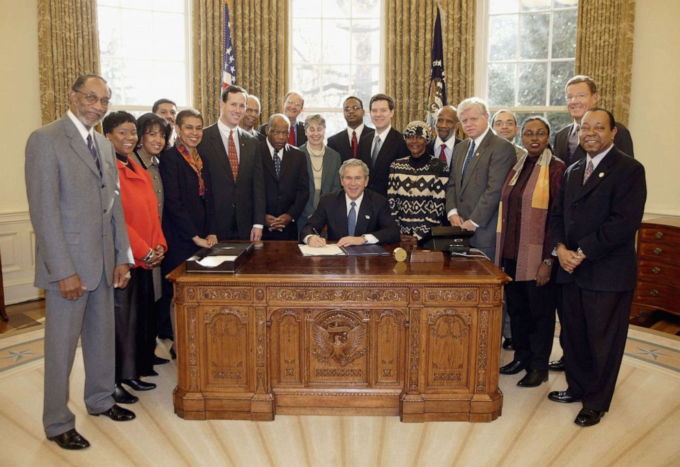 PHOTO: President George W. Bush signs H. R. 3491, the National Museum of African-American History and Culture Act, in the Oval Office, Dec. 16, 2003, in Washington, DC.
