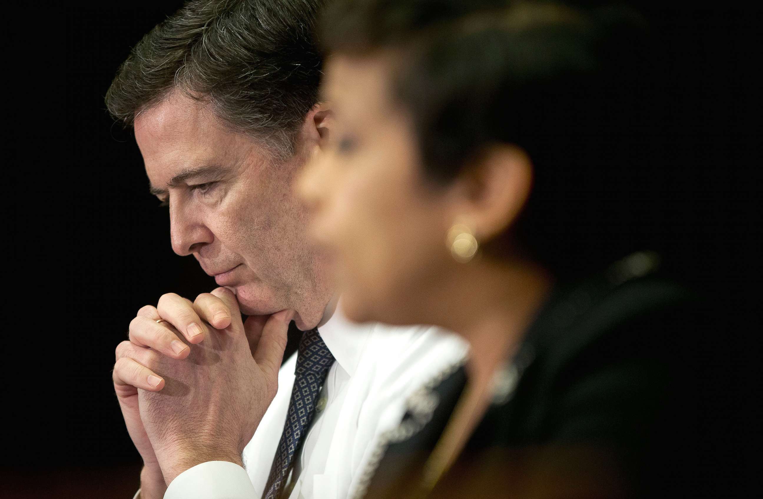 PHOTO: FBI Director James Comey listens at left as Attorney General Loretta Lynch speaks during a meeting with members of the media at Justice Department in Washington, D.C., Nov. 19, 2015.