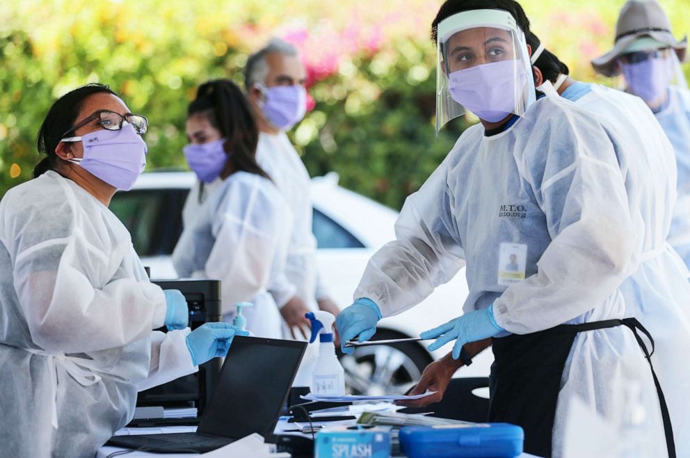 PHOTO: Healthcare workers facilitate tests at a drive-in COVID-19 testing center at M.T.O. Shahmaghsoudi School of Islamic Sufism on Aug. 11, 2020, in Los Angeles.