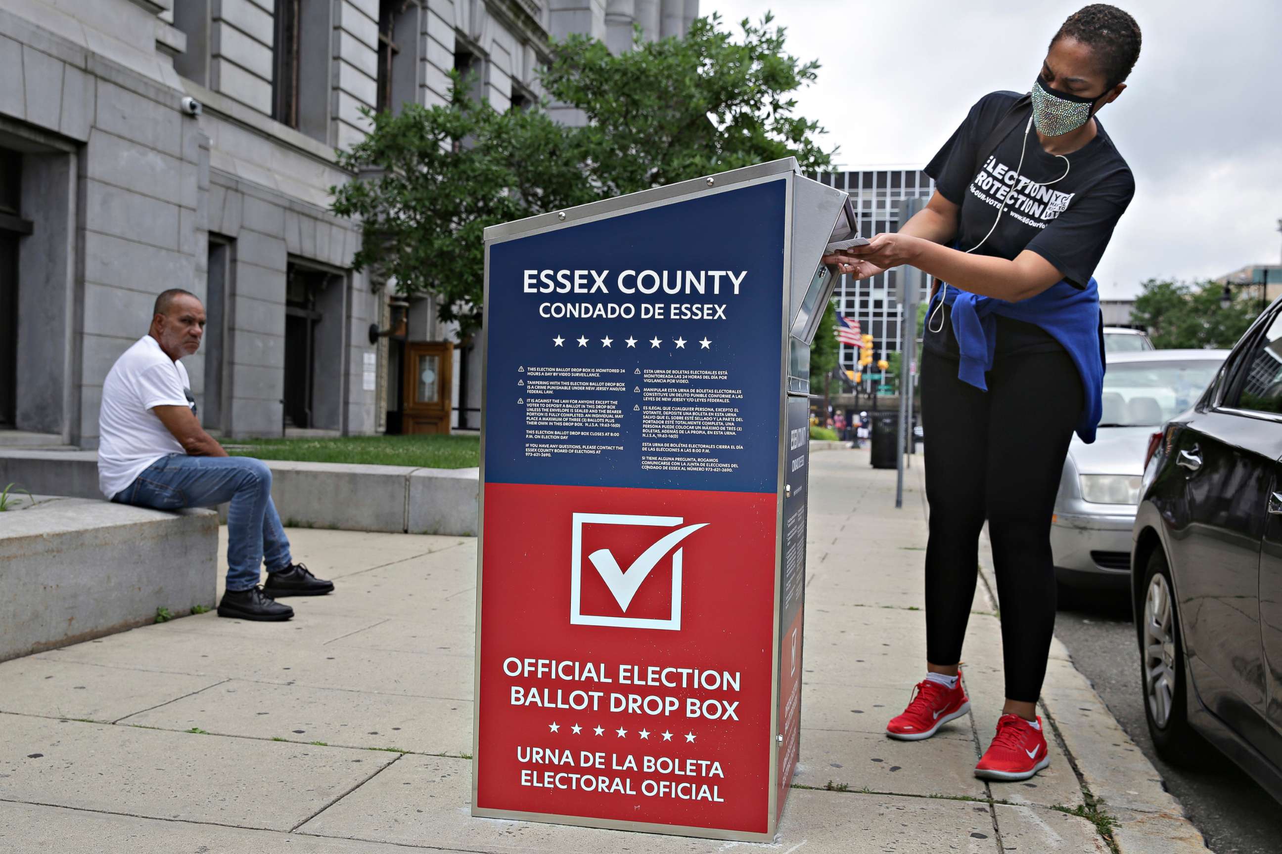 PHOTO: A woman drops her mail-in ballot into a drop box in Newark, N.J., July 7, 2020.