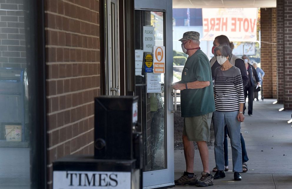 PHOTO: People standing in a queue wait to drop off their mail-in ballots at the Luzerne County elections board in Wilkes-Barre, Penn., Oct. 22, 2020.