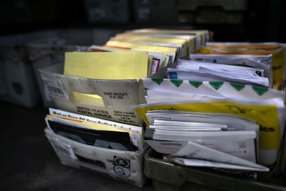 PHOTO: Yellow mail-in ballots and assorted mail sit in a U.S Postal Service truck while being delivered to a residential neighborhood, Oct. 8, 2020, in Phoenix.