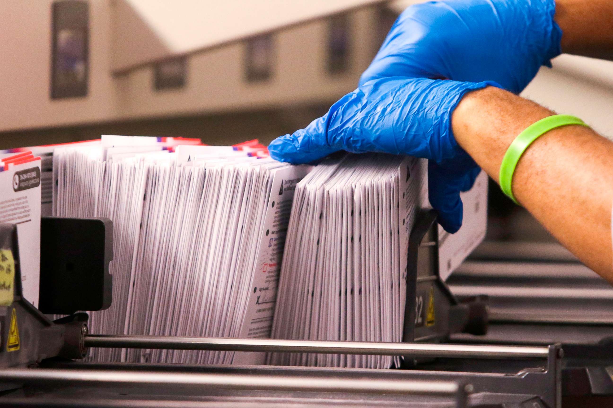 PHOTO: An election worker handles vote-by-mail ballots coming out of a sorting machine for the presidential primary at King County Elections in Renton, Washington,  March 10, 2020.