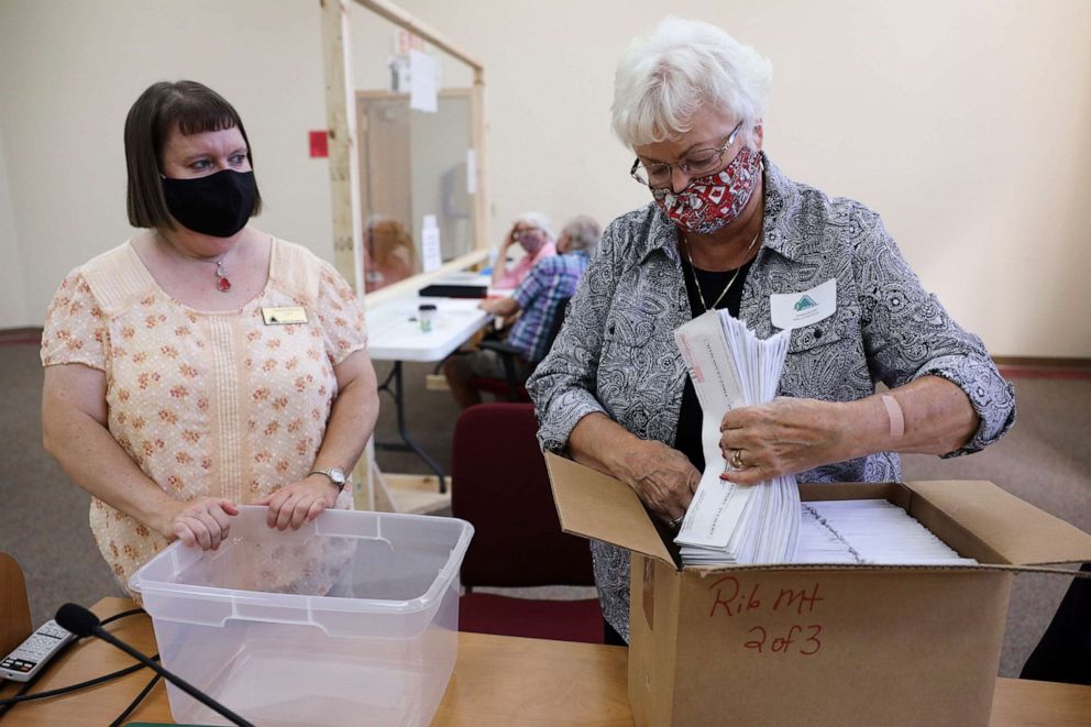 PHOTO: In this photo provided by Wisconsin Watch, Sharon Drefcinski, right, chief election inspector for the town of Rib Mountain, Wis., boxes mailed-in absentee ballots to send to the county for archiving, during the primary on Aug. 11, 2020. 
