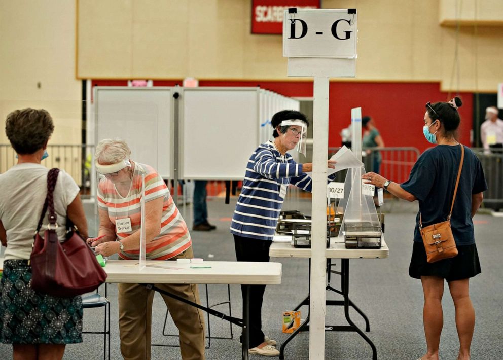 PHOTO: Election workers assist voters at Scarborough High School, July 14, 2020, in Scarborough, Maine.