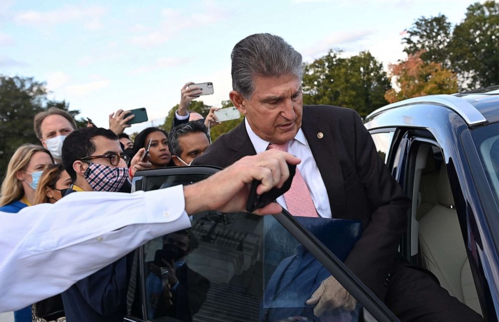 PHOTO: Sen. Joe Manchin, D-W.Va., gets into a car as members of the press ask question, after he left the US Capitol in Washington, D.C., on Oct. 28, 2021.