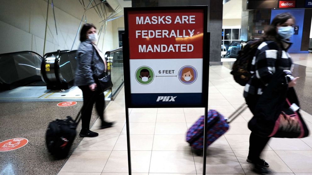 PHOTO: People walk through Sky Harbor International Airport in Phoenix where new COVID-19 cases are down but health experts warn cases may rise with the introduction of the omicron strain, Dec. 18, 2021, in Phoenix.