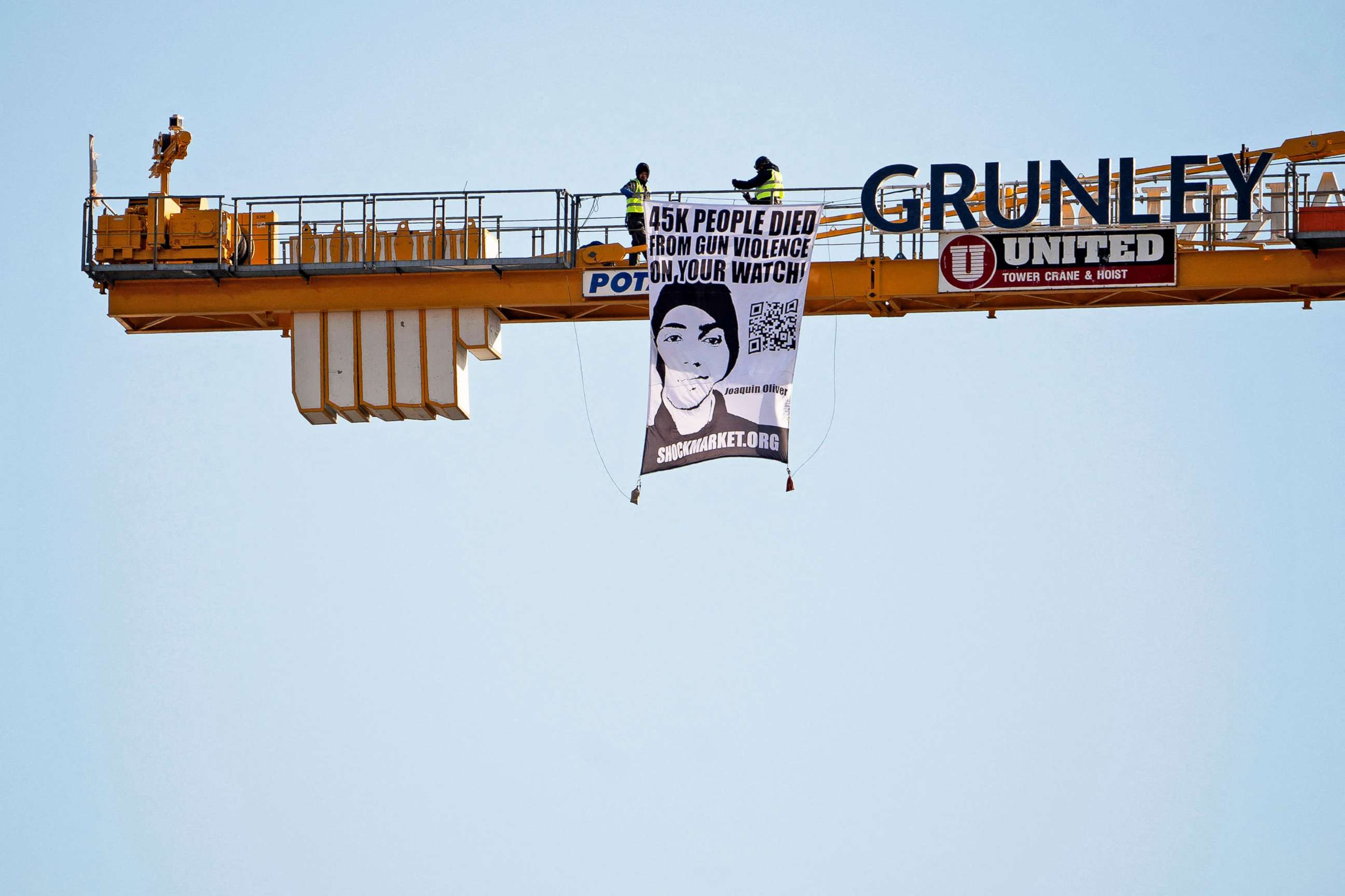 PHOTO: Manuel Oliver displays a banner asking government to prioritize gun violence prevention from a construction crane near the White House in Washington, D.C., Feb. 14, 2022. Oliver's son Joaquin Oliver was killed in the Parkland School shooting.