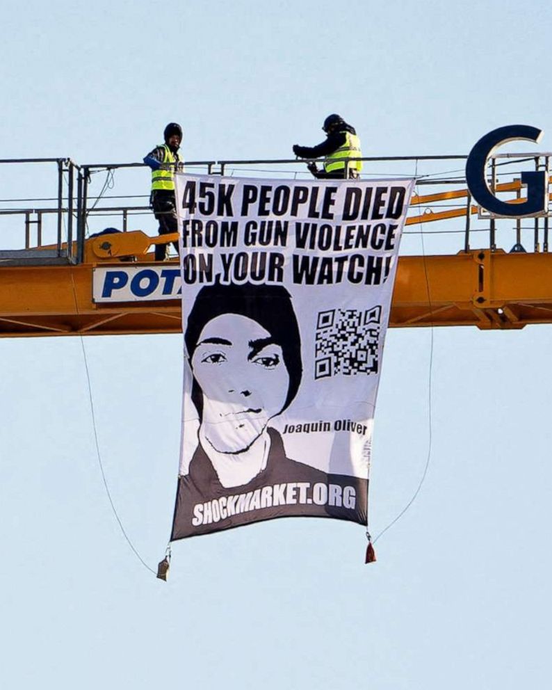 PHOTO: Manuel Oliver displays a banner asking government to prioritize gun violence prevention from a construction crane near the White House in Washington, D.C., Feb. 14, 2022. Oliver's son Joaquin Oliver was killed in the Parkland School shooting.