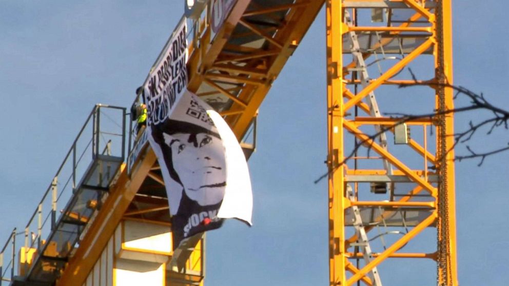 PHOTO: Manuel Oliver displays a banner asking government to prioritize gun violence prevention from a construction crane near the White House in Washington, D.C., Feb. 14, 2022. Oliver's son Joaquin Oliver was killed in the Parkland School shooting.