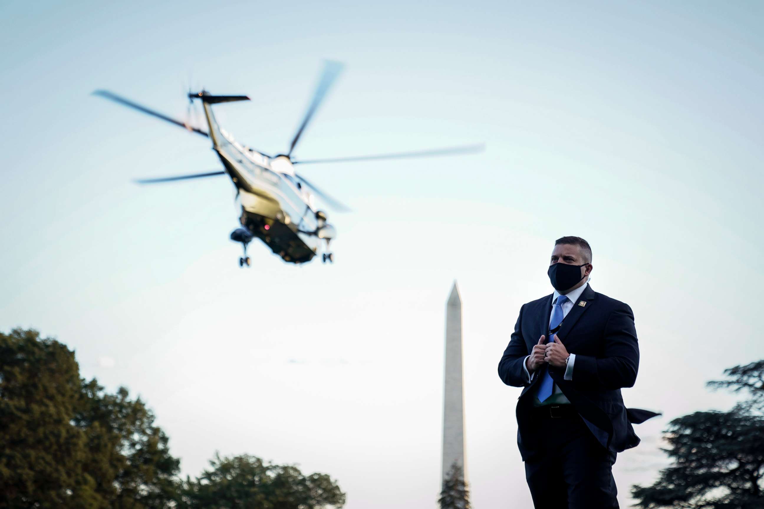 PHOTO: A U.S. Secret Service agent wears a face covering as Marine One, with President Donald Trump onboard, leaves the White House for Walter Reed National Military Medical Center from the South Lawn of the White House, Oct.2, 2020.