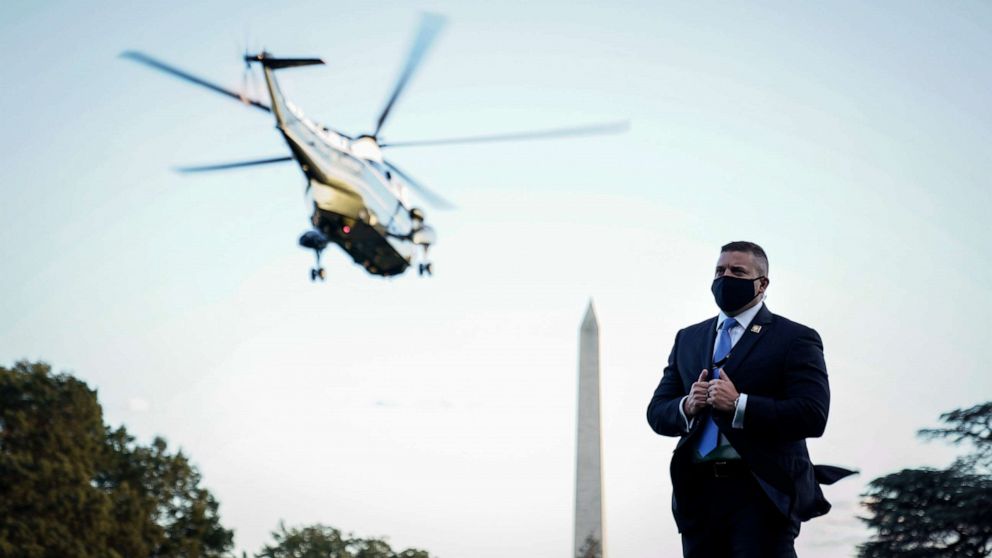 PHOTO: A U.S. Secret Service agent wears a face covering as Marine One, with President Donald Trump onboard, leaves the White House for Walter Reed National Military Medical Center from the South Lawn of the White House, Oct.2, 2020.