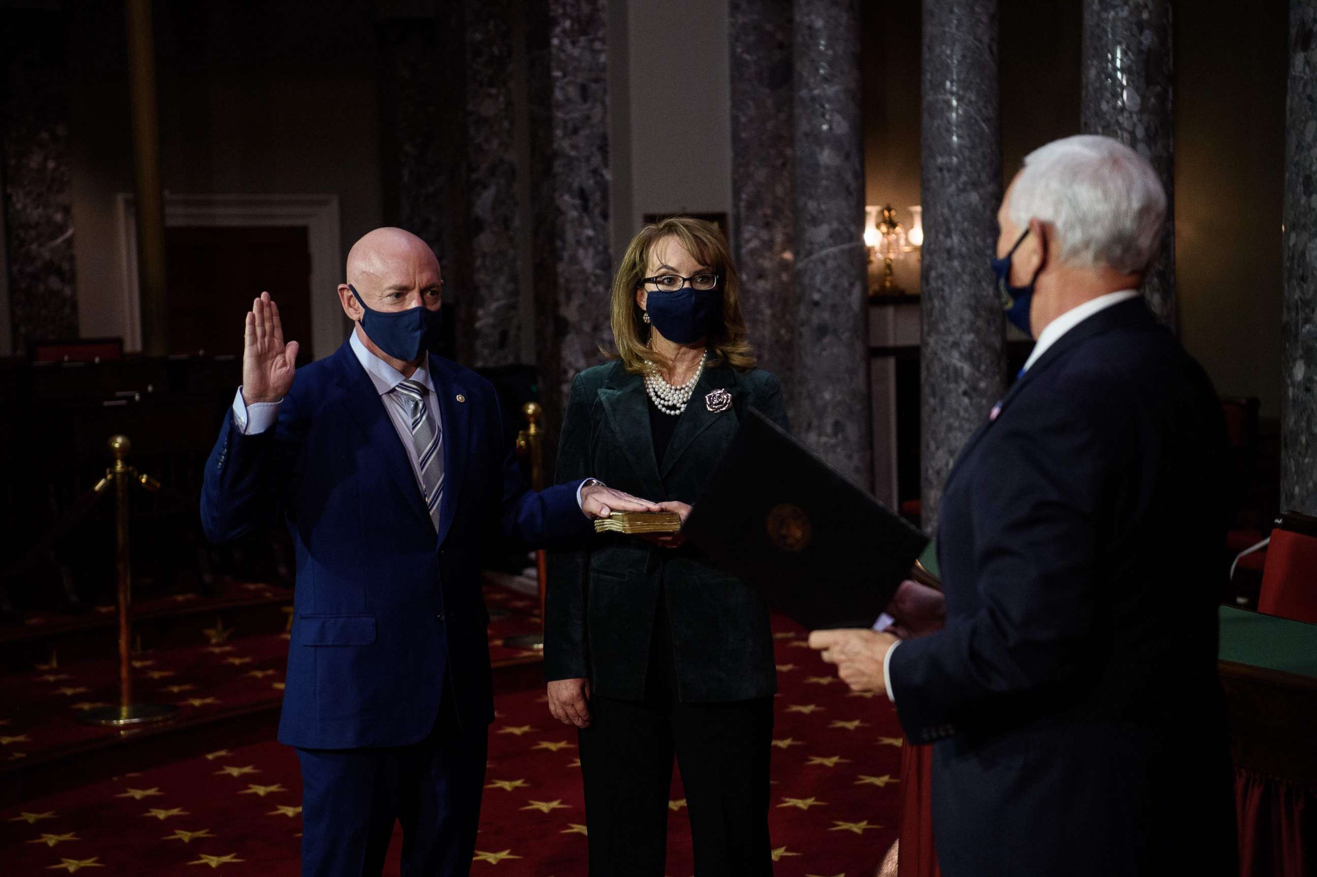 PHOTO: Democratic Senator from Arizona, Mark Kelly, with his wife, former Representative from Arizona Gabby Giffords, is sworn in by Vice President Mike Pence during a ceremonial re-enactment at the U.S. Capitol in Washington, Dec. 2, 2020.