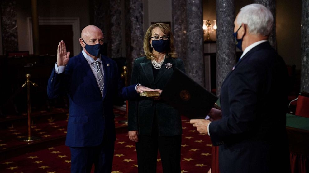 PHOTO: Democratic Senator from Arizona, Mark Kelly, with his wife, former Representative from Arizona Gabby Giffords, is sworn in by Vice President Mike Pence during a ceremonial re-enactment at the U.S. Capitol in Washington, Dec. 2, 2020.