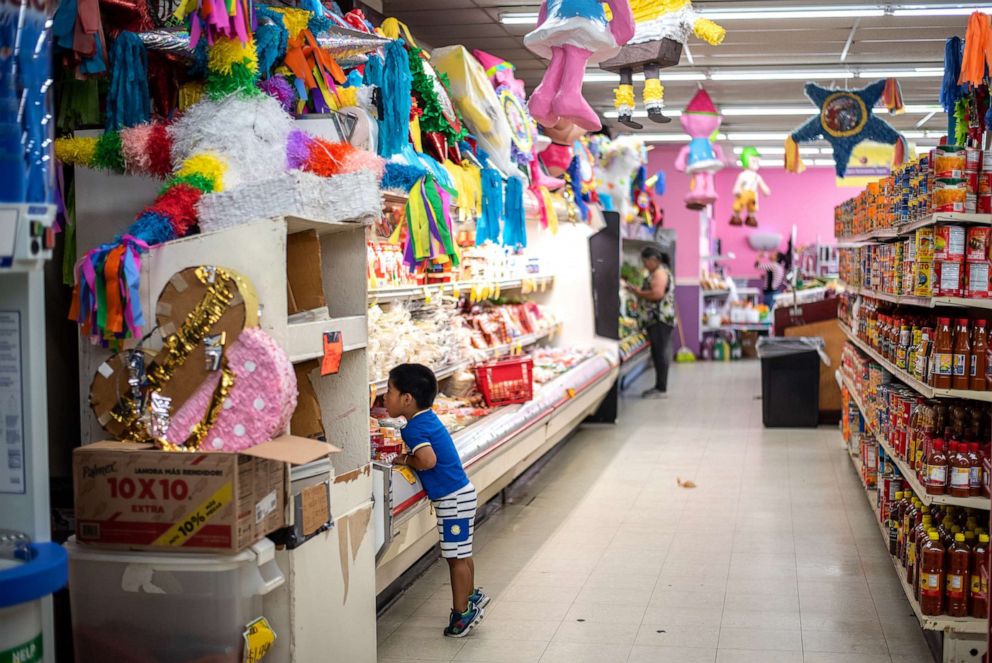 PHOTO: Alexander Salvador Serrano, 3, peeks at snacks in a cooler at Zamora Fresh Market in Marshalltown, Iowa, Aug. 7, 2019.