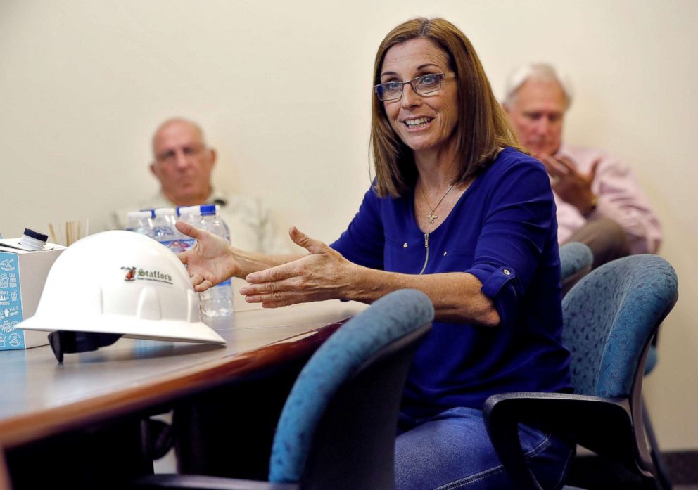 PHOTO: US Representative Martha McSally protests against US Representative Kyrsten Sinema for the Senate seat vacated by retired US Senator Jeff Flake for employees at a manufacturing and training center for cranes in Phoenix on October 3, 2018.