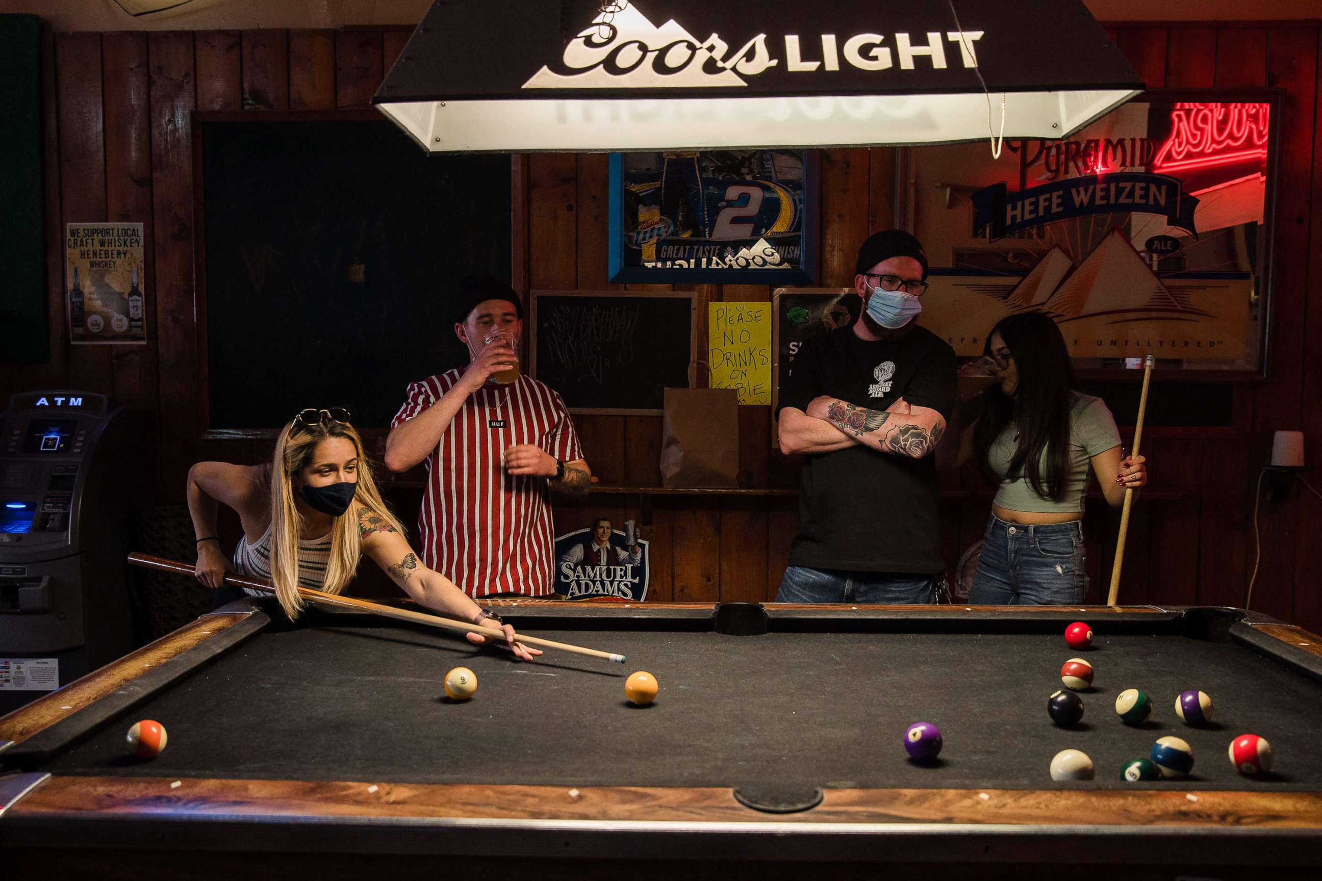 PHOTO: People wearing face masks play pool at Cheswick's West bar in Ocean Beach in San Diego, Feb. 13, 2021.