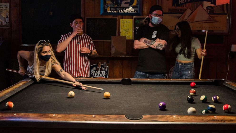 PHOTO: People wearing face masks play pool at Cheswick's West bar in Ocean Beach in San Diego, Feb. 13, 2021.