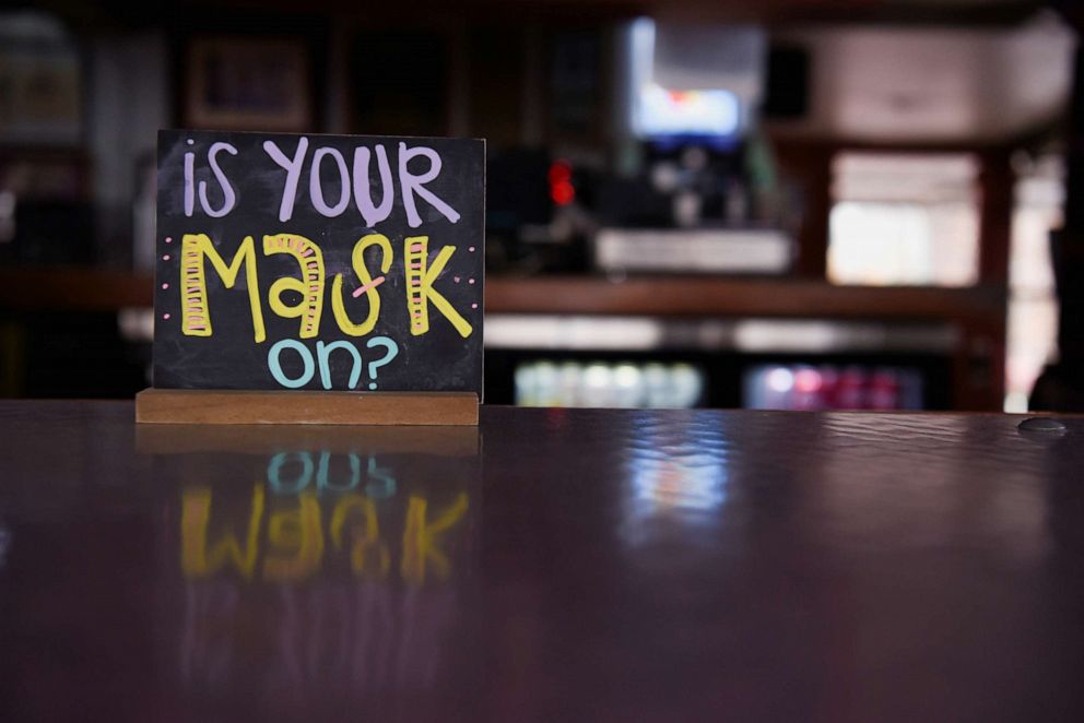 A sign promotes mask-wearing at a bar in Houston as the state of Texas prepares to lift its mask mandate and reopen businesses to full capacity.