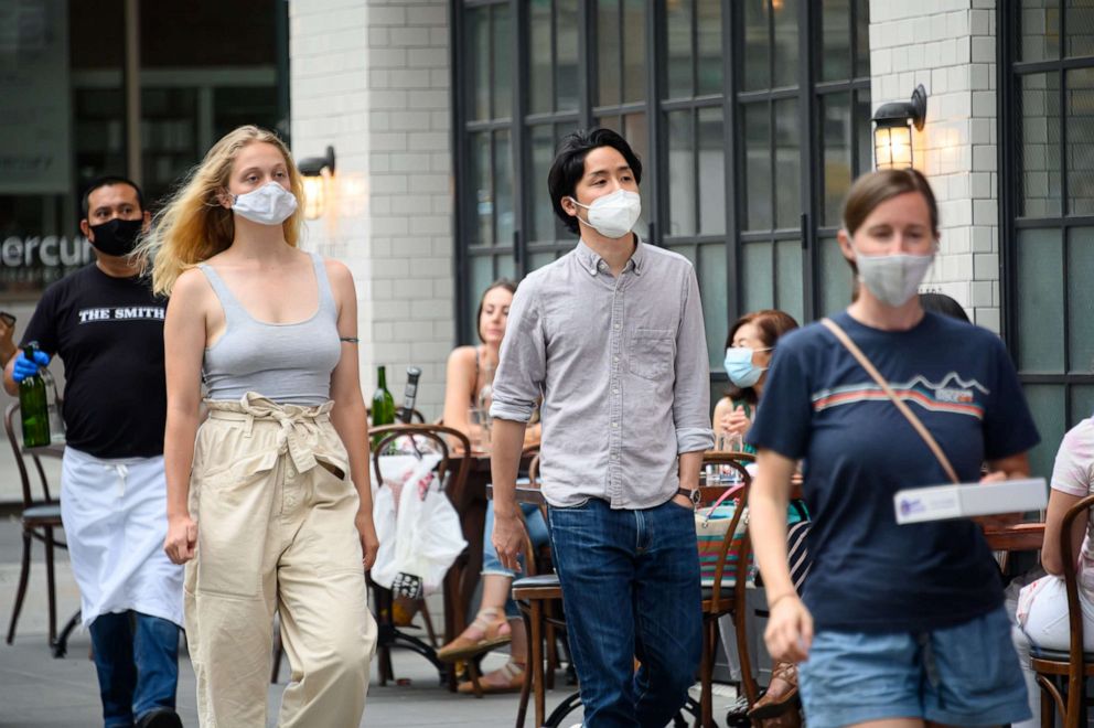 PHOTO: People wear a protective face mask outside The Smith on the Upper East Side as New York City moves into Phase 2 of re-opening following restrictions imposed to curb the coronavirus pandemic on June 30, 2020.